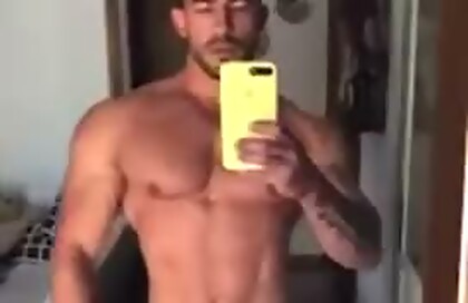 Guy in Black Posing Trunks In Front Of A Mirror